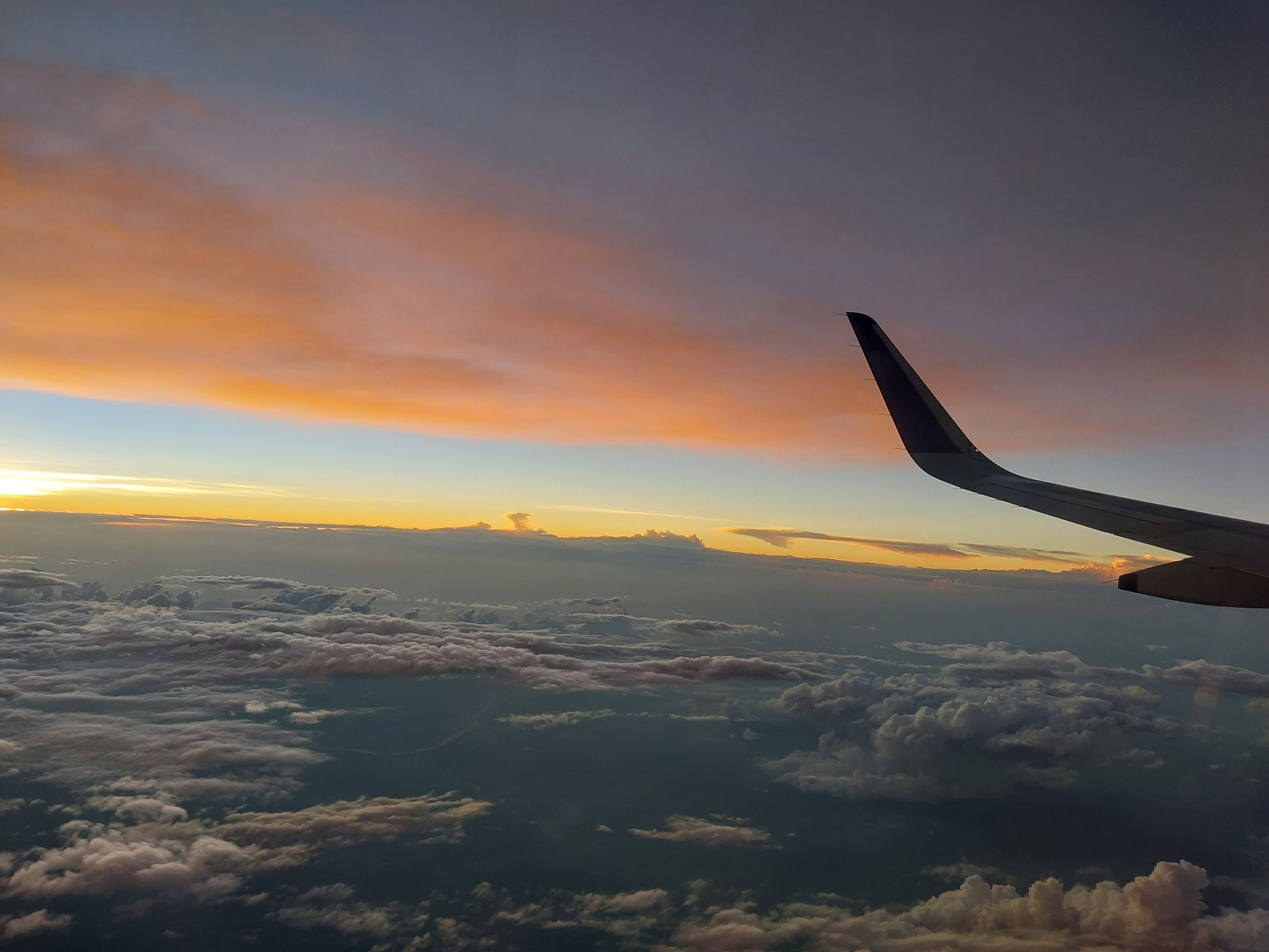 Sunset above the clouds, seen from an aircraft window